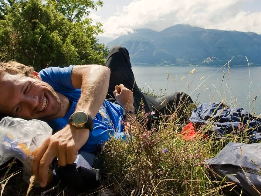 Turgåer hviler i lyngen med sekken ved siden av seg, over en fjord