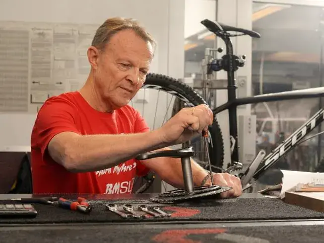 Mekaniker monterer kranken på en Scott-sykkel